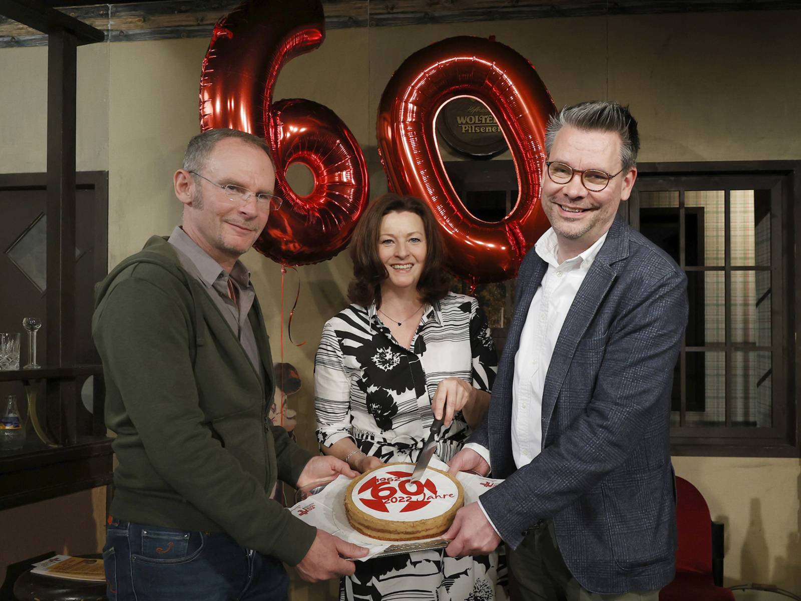 Christoper v.Berlepsch, Miriam Schröder und Florian Battermann mit einer Geburtstagstorte und Luftballons zum 60. Geburtstag des Neues Theaters Hannover.